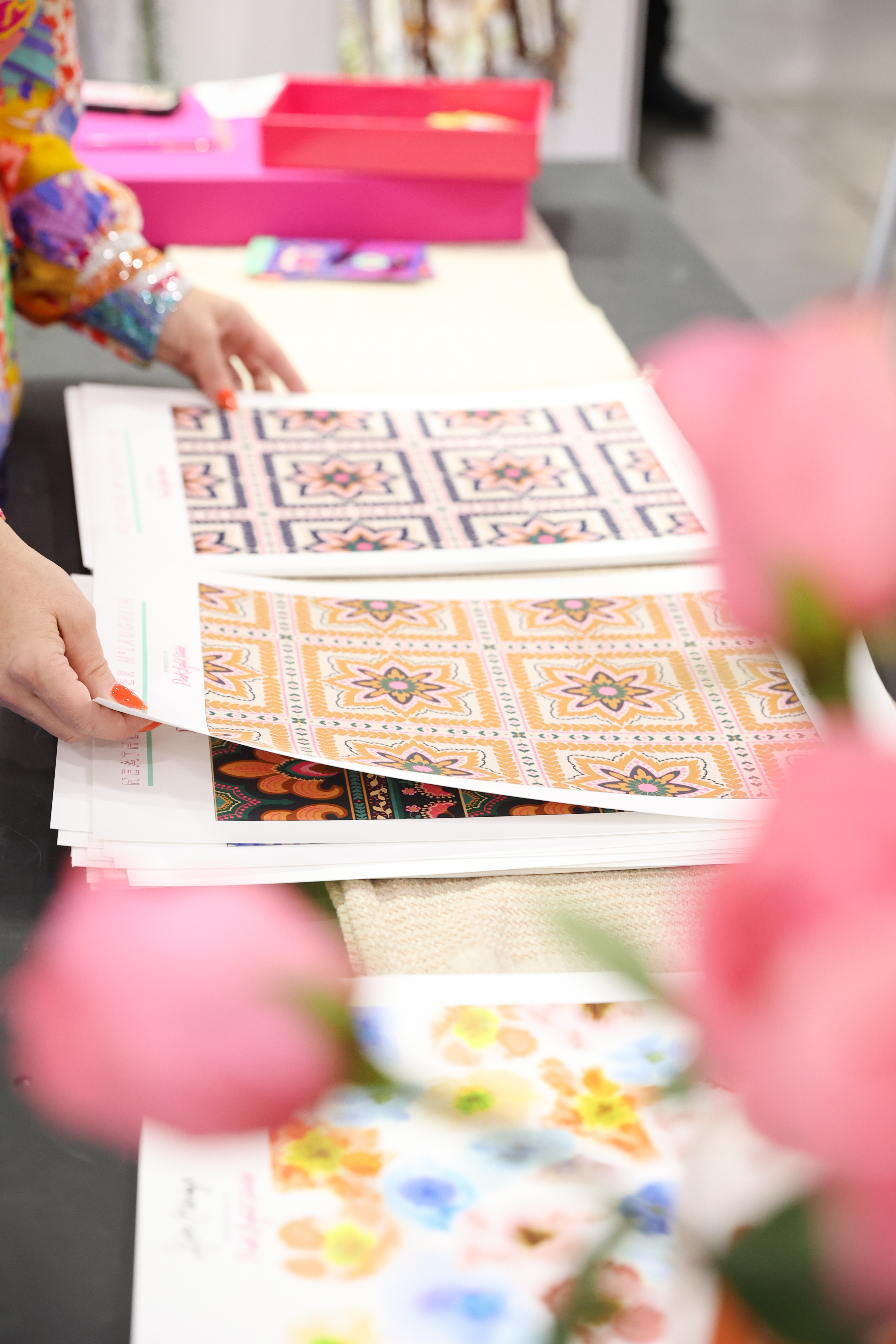 Designer reviewing printed textile designs with intricate patterns at Texworld Los Angeles